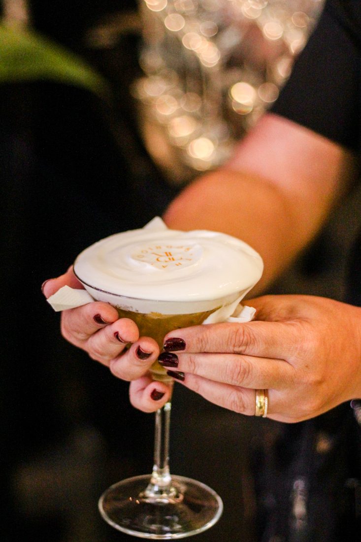 Drink autoral da Life Drink Bar com espuma e o logo aplicado, servido em taça